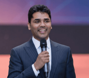 A man speaking at an industry event with a microphone